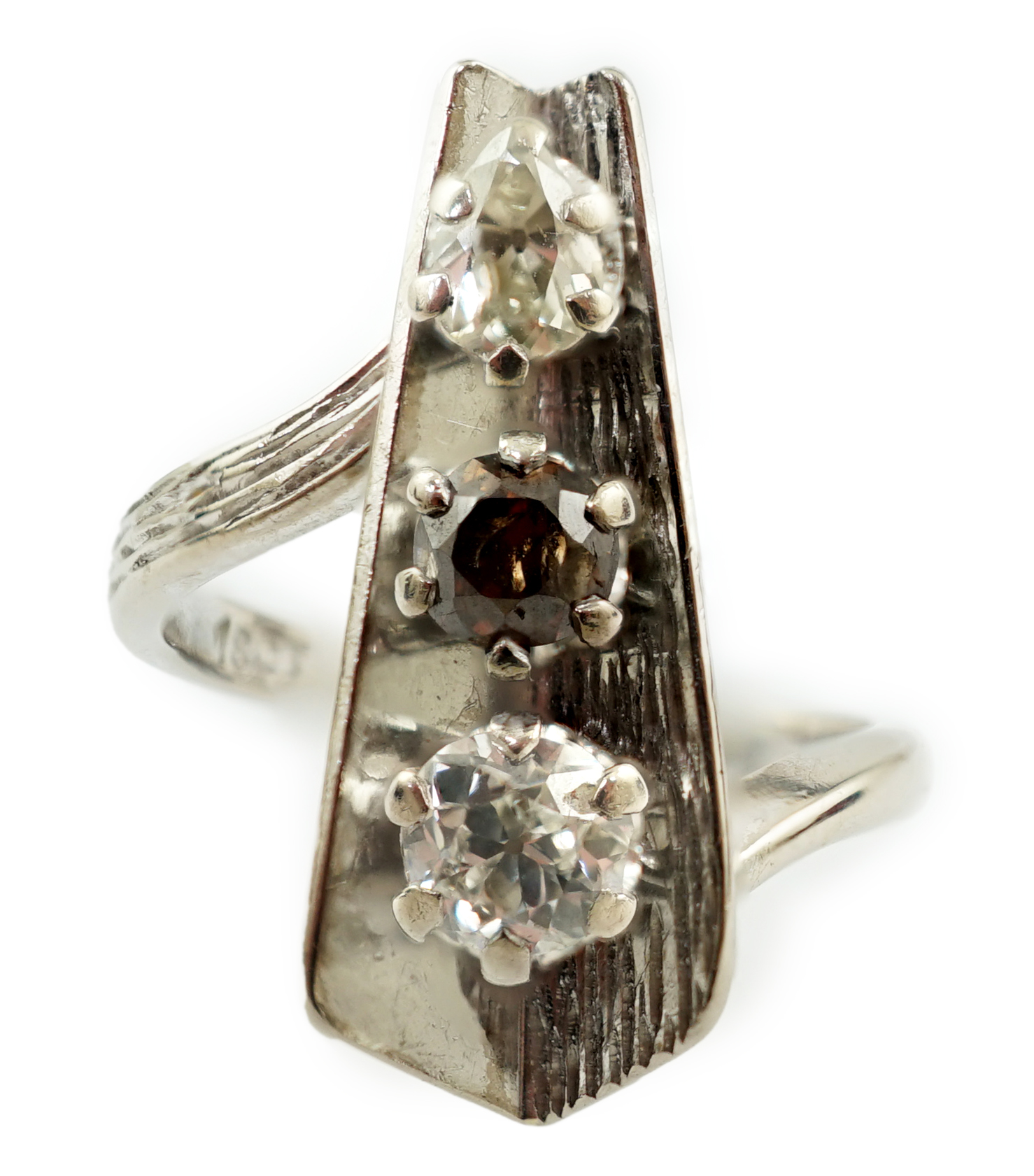 A 1970's 18ct white gold and graduated three stone diamond modernist ring
